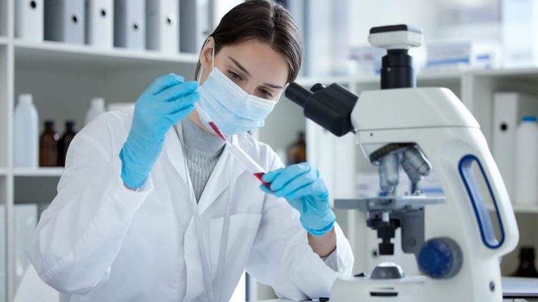 Femme analysant un échantillon de sans en laboratoire - crédit photo : PeopleImages.com - Yuri A via Shutterstock