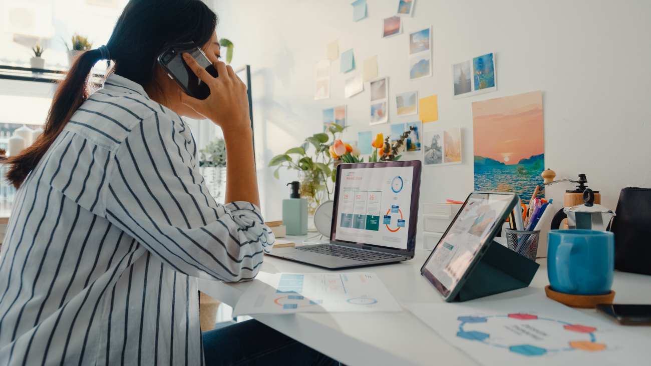 Femme au téléphone devant l'ordinateur - crédit photo : Tirachard Kumtanom via Shutterstock