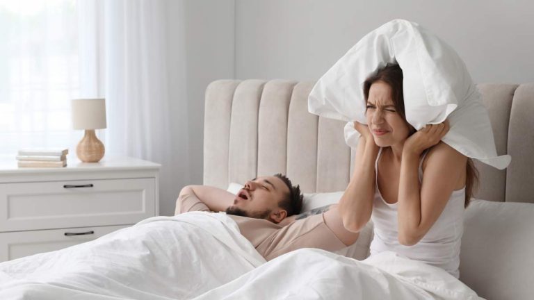 Homme qui ronfle et femme qui stresse - crédit photo : New Africa via Shutterstock