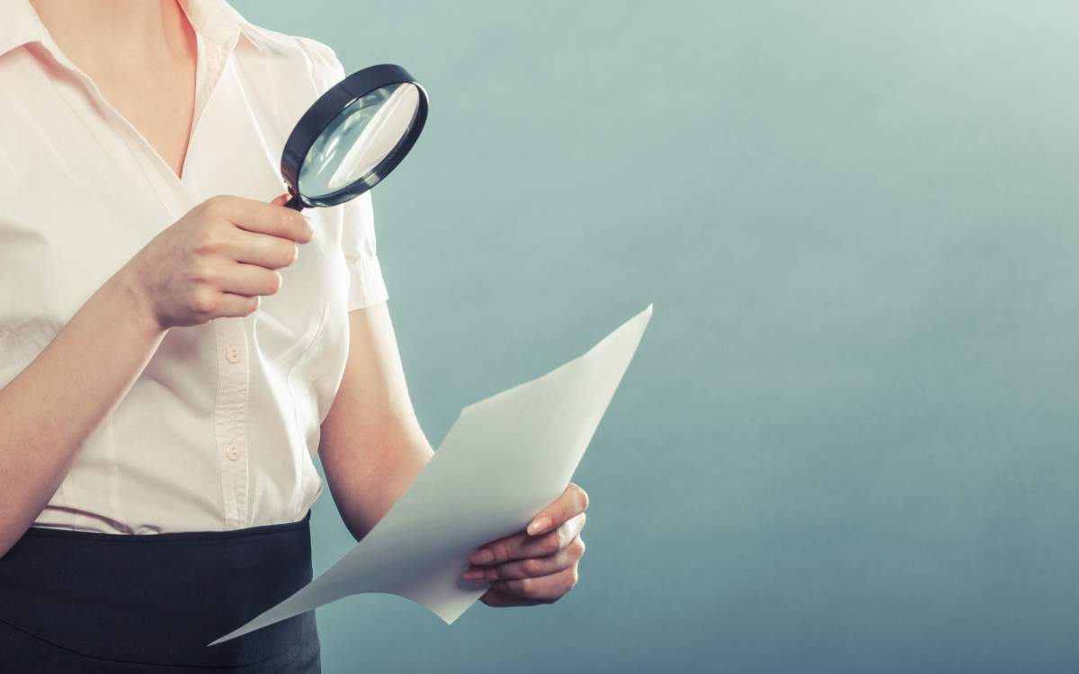 lecture contrat à la loupe - crédit photo : Voyagerix via Shutterstock