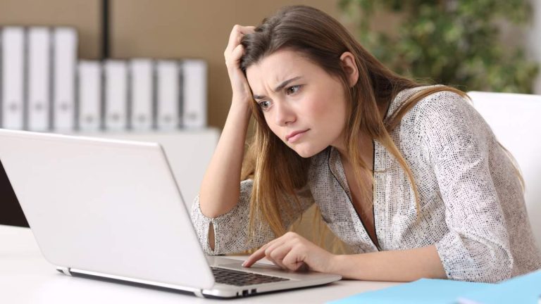 Femme qui se prend la tête devant son ordinateur